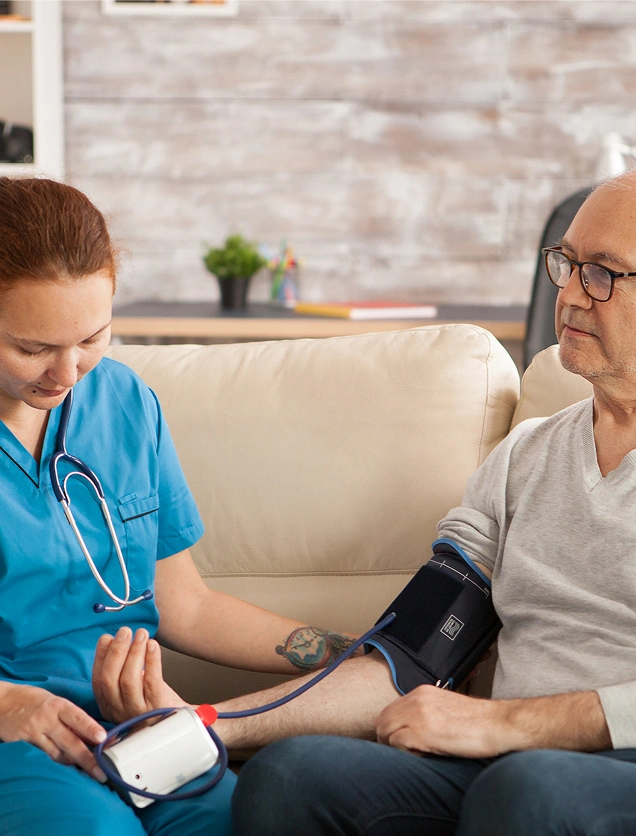 Home healthcare nurse taking an elderly male patient’s blood pressure using a manual monitor in his living room. Home healthcare nurse taking an elderly male patient's blood pressure using a manual monitor in his living room.