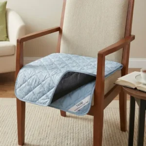 A blue absorbent incontinence chair pad placed on a living room armchair - Alfa Healthcare Supply NY.